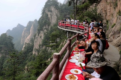 命懸けの食事会？断崖絶壁で観光イベント 中国・老君山