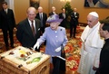 バチカンでローマ・カトリック教会のフランシスコ（Francis）法王（右）と会談し、贈り物を進呈する英国のエリザベス女王（Queen Elizabeth II、左）とフィリップ殿下（Prince Philip、中央、2014年4月3日撮影）。(c)AFP/STEFANO RELLANDINI