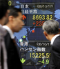 都内の証券会社に設置された株価表示板を見る歩行者たち（2008年10月17日撮影）。(c)AFP/Toru YAMANAKA
