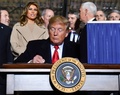 国防権限法に署名するドナルド・トランプ大統領と、後ろで見守る（前から2列目左から）メラニア夫人、マイク・ペンス副大統領（2019年12月20日撮影）。(c)Nicholas Kamm / AFP