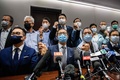 中国・香港の立法会で開いた記者会見で集団辞職を発表し、手を取り合う民主派議員ら（2020年11月11日撮影）。(c)Anthony WALLACE / AFP