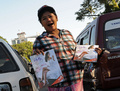ミャンマー・ヤンゴン（Yangon）で、路上で性教育雑誌「Hyno」を売る女性（2012年12月20日撮影、資料写真）。(c)AFP/Soe Than WIN