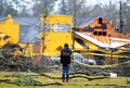 米ミシシッピ（Mississippi）州ハッティズバーグ（Hattiesburg）市で竜巻に遭い損壊したサザン・ミシシッピ大学（University of Southern Mississippi）の校舎を「iPhone（アイフォーン）」で撮影する学生（2013年2月11日撮影）。(c)AFP/Getty Images/Sean Gardner