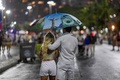 ブラジル・リオデジャネイロのコパカバーナビーチを歩くカップル（2021年12月31日撮影）。(c)DANIEL RAMALHO / AFP
