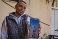 レバノンのトリポリで、11年前に撮影された政府軍兵士だった頃の自身の写真を見せるシリア人難民のファハド・ルタイバンさん（30）。政府軍からの再招集から逃れるため、2013年にシリア・ラッカを離れた（2021年2月23日撮影）。(c)IBRAHIM CHALHOUB / AFP