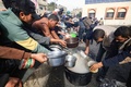 パレスチナ自治区ガザ南部ラファで、食料の配給を待つ人々（2023年12月23日撮影）。(c)MAHMUD HAMS / AFP