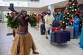 フィジー・ナンディの空港に到着し、民族衣装を着たダンサーに迎えられる観光客（2021年12月1日撮影）。(c)Leon LORD / AFP