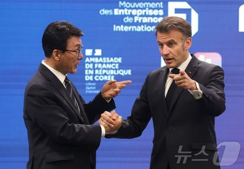 韓国のキム・ミンソク（金民錫）首相と握手を交わすマクロン大統領(c)news1