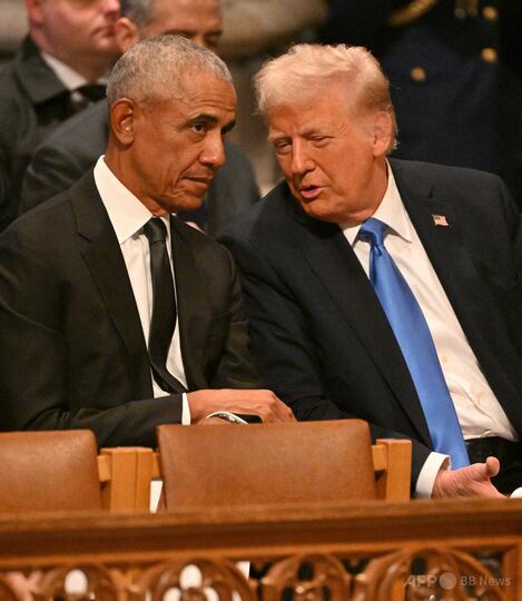 米首都のワシントン大聖堂で行われたジミー・カーター元米大統領の国葬で、ドナルド・トランプ大統領（右）と話すバラク・オバマ元大統領（2025年1月9日撮影）。(c)ROBERTO SCHMIDT/AFP