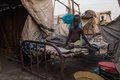 南スーダンのマラカルの避難民キャンプで、ベッドに座る少年（2018年3月13日撮影）。(c)AFP PHOTO / Stefanie GLINSKI