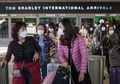 米カリフォルニア州ロサンゼルス空港で、アジア発の航空機で到着したマスク姿の人々（2020年1月29日撮影）。(c)Mark RALSTON / AFP