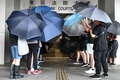 「覆面禁止規則」違反の罪で起訴されたデモ参加者2人が出廷した香港東区の裁判所で傘をさす民主派の活動家（2019年10月7日撮影）。(c)Mohd RASFAN / AFP