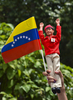 大統領選挙が行われたベネズエラの首都カラカス（Caracas）でウゴ・チャベス（Hugo Chavez）大統領の支持者が掲げたベネズエラ国旗とチャベス大統領の人形（2012年10月7日撮影）。(c)AFP/Luis Acosta