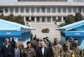 南北軍事境界線上の板門店を訪問し、在韓米軍のビンセント・ブルックス司令官（右から3番目）と並ぶレックス・ティラーソン米国務長官（中央）、およびその背後で韓国側をのぞき込む北朝鮮の兵士たち（2017年3月17日撮影）。(c)AFP/Lee Jin-man