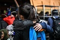 香港理工大学の構内から脱出するため、歩道橋から幹線道路へロープで下りる前に、抱き合うデモ参加者（2019年11月18日撮影）。(c)AFP/Anthony WALLACE