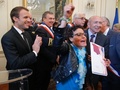 仏中部オルレアンで、フランスの市民権を得て、エマニュエル・マクロン大統領（左）の横で喜ぶ女性（2017年7月27日撮影）。(c)AFP/Michel Euler