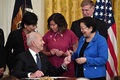 米ホワイトハウスでヘイトクライム（憎悪犯罪）対策法案に署名し、ペンをメイジー・ヒロノ上院議員に渡すジョー・バイデン大統領（左手前、2021年5月20日撮影）。(c) Nicholas Kamm / AFP
