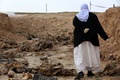 ISに殺害された人々の集団墓地がイラク・シンジャルで発見された翌日、消息不明の親族の手掛かりを探して歩くヤジディー教徒の女性（2015年2月3日撮影）。(c)AFP / Safin Hamed