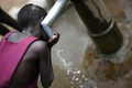 2007年10月19日、ウガンダのOlilim国内避難民キャンプで、井戸の水を飲む女の子。(c)AFP/Roberto SCHMIDT
