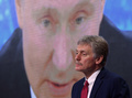 ロシアの首都モスクワで行われた記者会見で、ウラジーミル・プーチン大統領が映し出されたスクリーンの前で話すドミトリー・ペスコフ大統領報道官（2020年12月17日撮影、資料写真）。(c)NATALIA KOLESNIKOVA / AFP