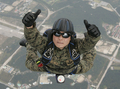 韓国・鶏龍（Gyeryong）の陸海空軍本部で前月29日、1日に61年を迎える「国軍の日（Armed Forces Day）」に向けたリハーサルが行われた。1950年～53年の朝鮮戦争で、韓国は1953年、北朝鮮と休戦協定を結んだが、法的には戦争状態にある。

写真は、鶏龍の陸海空軍本部で実施された「国軍の日」に向けた軍事演習で、上空のヘリコプターからパラシュート降下しながら、カメラに向かって親指を立てる韓国軍特殊部隊兵士（2009年9月29日撮影）。(c)AFP/JO YONG-HAK