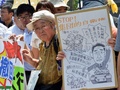 都内・国会議事堂そばで行われた安倍政権への抗議デモで、プラカードを掲げスローガンを唱えるデモ参加者（2014年7月14日撮影）。(c)AFP/Yoshikazu TSUNO