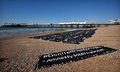 英南部ブライトンの海岸で、地中海の難民船問題をめぐる英政府の対応を非難する国際人権団体アムネスティ・インターナショナルが抗議行動の一環として並べた遺体袋（2015年4月22日撮影）。(c)AFP/BEN STANSALL