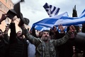 ギリシャの首都アテネの国会議事堂の前で、ギリシャ国旗を振って年金改革などに抗議する農業従事者たち（2016年2月12日撮影）。(c)AFP/ANGELOS TZORTZINIS
