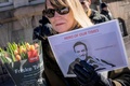 デンマーク・コペンハーゲンのロシア大使館前でアレクセイ・ナワリヌイ氏の写真を手にして反プーチン政権デモに参加する人（2024年3月17日撮影）。(c)Emil Nicolai Helms / Ritzau Scanpix / AFP