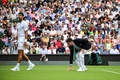 テニス、ウィンブルドン選手権、男子シングルス1回戦。芝の状態を確認する審判（右）の横を通るノバク・ジョコビッチ（2023年7月3日撮影）。(c)Daniel LEAL / AFP