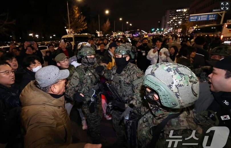 4日未明、韓国国会前で、国会敷地内に進入しようとする戒厳軍を阻止する市民ら(c)news1