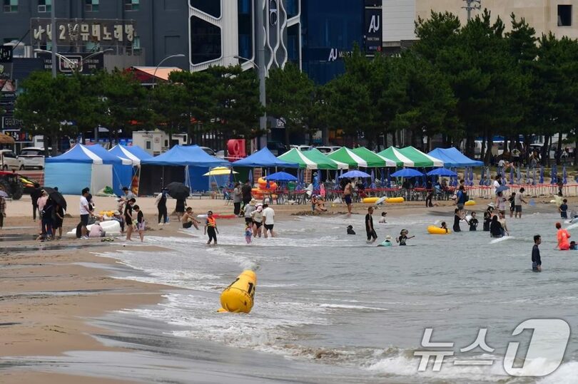 2025年7月13日午後、慶尚北道浦項市北区の迎日台海水浴場で涼を取る避暑客ら(c)news1