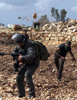 パレスチナ自治区ヨルダン川西岸（West Bank）で、イスラエルの境界を警備するイスラエル軍兵士に投石するパレスチナ人の少年（2013年3月1日撮影）。(c)AFP/ABBAS MOMANI