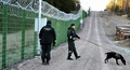ロシア国境沿いに試験的に設置されたフェンス近くを歩く国境警備隊。フィンランド南東部イマトラ付近で（2023年10月26日撮影）。(c)Jussi Nukari / Lehtikuva / AFP