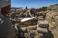 エジプト・ルクソール近郊で発見された古代都市遺構で、遺骨にカバーをかける作業員（2021年4月10日撮影）。(c)Khaled DESOUKI / AFP