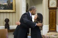 米ワシントンD.C.（Washington D.C.）ホワイトハウス（White House）の大統領執務室（Oval Office）で、エボラ出血熱から回復した看護師のニーナ・ファム（Nina Pham）さん（右）を抱きしめるバラク・オバマ（Barack Obama）米大統領（左、2014年10月24日撮影）。(c)AFP/Saul LOEB