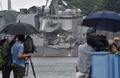 神奈川県横須賀市の南西沖でフィリピン船籍のコンテナ船と衝突した米海軍イージス駆逐艦「フィッツジェラルド」を撮影するテレビカメラマン。横須賀港で（2017年6月18日撮影）。(c)AFP/Kazuhiro NOGI
