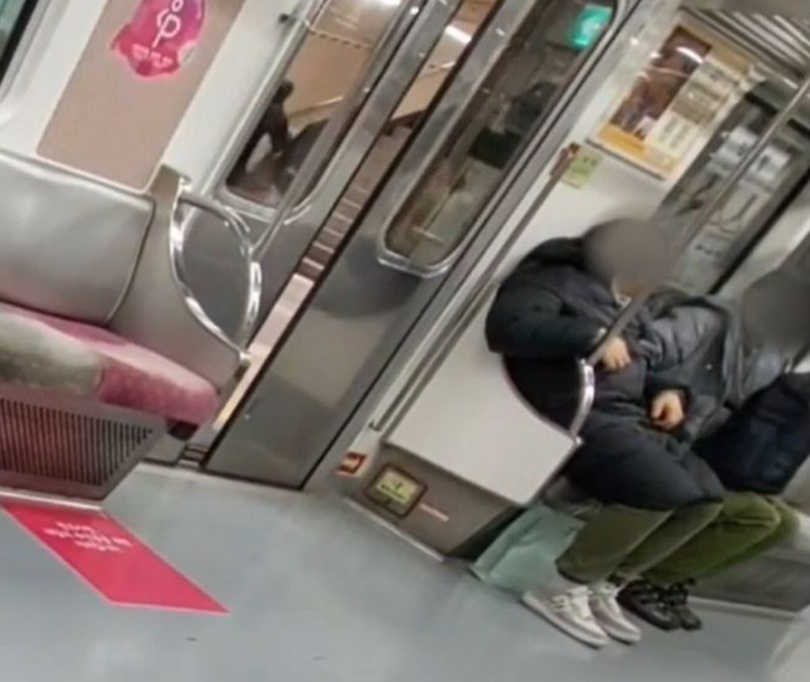 電車内の被害者のポケットに手を入れて探す50代の男性の姿=ソウル警察庁地下鉄警察隊提供(c)NEWSIS