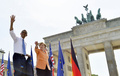 ドイツ首都ベルリン（Berlin）のブランデンブルク門（Brandenburg Gate）前に集まった人々に手を振るバラク・オバマ（Barack Obama）米大統領（左）とアンゲラ・メルケル（Angela Merkel）独首相（右、2013年6月19日撮影）。(c)AFP/JEWEL SAMAD