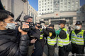 中国人ジャーナリストの張展氏の裁判が開かれる上海市浦東新区人民法院前で報道陣の撮影を阻止する警察官ら（2020年12月28日撮影）。(c)Leo RAMIREZ / AFP