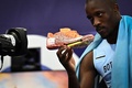 パリ五輪、陸上男子200メートル決勝。ゴール後にカメラに向かってスパイクを見せるボツワナのレツィレ・テボゴ（2024年8月8日撮影）。(c)Ben STANSALL / AFP