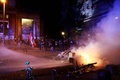 ドイツ北部ハンブルクで行われた、主要20か国・地域（G20）に抗議するデモの現場で、燃やされたごみ容器に放水銃を使用する機動隊（2017年7月6日撮影）。(c)AFP/Odd ANDERSEN