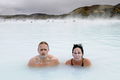 写真はアイスランドの首都レイキャビク（Reykjavik）郊外にある温泉｢ブルーラグーン（Blue Lagoon）｣を楽しむ観光客。ブルーラグーンは水の色が青と緑であることから、この名で呼ばれている。健康効果もうたわれている（2009年4月26日撮影）。(c)AFP/OLIVIER MORIN