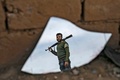 シリア東部デリゾール県バグズ村で、割れた鏡に映ったクルド人主体の民兵組織「シリア民主軍（SDF）」の兵士（2019年3月12日撮影）。(c)Delil souleiman / AFP