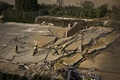 中国東部山東（Shandong）省青島（Qingdao）で、石油パイプラインの爆発で裂けた道路（2013年11月22日撮影）。(c)AFP