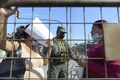 ギャング同士の抗争が起きた南米エクアドル・グアヤキルの刑務所に集まった受刑者の親族と話す兵士（2021年9月29日撮影）。(c)Fernando MENDEZ / AFP
