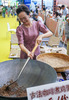 コーヒー産業館でコーヒー豆の焙煎体験をする来場者（2024年7月24日撮影）。(c)Xinhua News