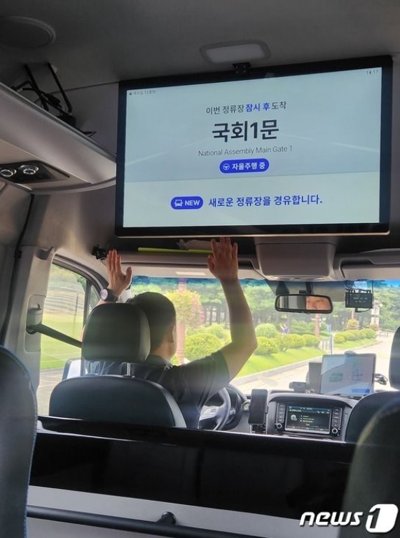 自動運転ロボシャトルで、運転手がハンドルから手を離している(c)news1