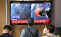 韓国初の月探査機を載せた宇宙開発企業スペースXの「ファルコン9」ロケットの打ち上げを報じるテレビ番組を見る人々。ソウルの鉄道駅にて（2022年8月5日撮影）。(c) Jung Yeon-je / AFP
