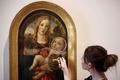 英ロンドンのコートールド美術館の「Art and Artifice: Fakes from the Collection（アートと策略：コレクションの贋作）」展でサンドロ・ボッティチェリをまねたウンベルト・ギュンティの作品を見る同館の職員（2023年6月16日撮影）。(c)HENRY NICHOLLS / AFP